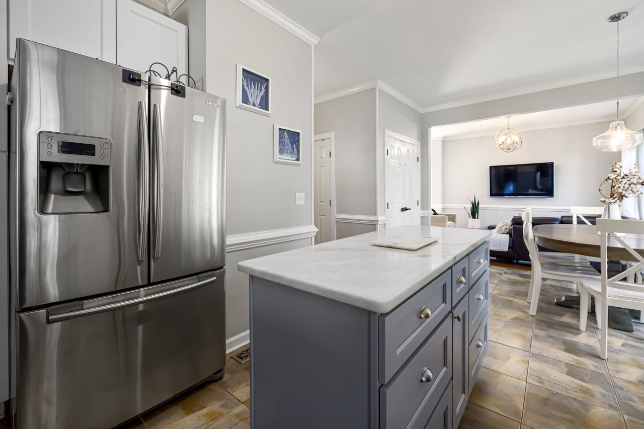 Elegant modern kitchen featuring a marble countertop and stainless steel appliances.
