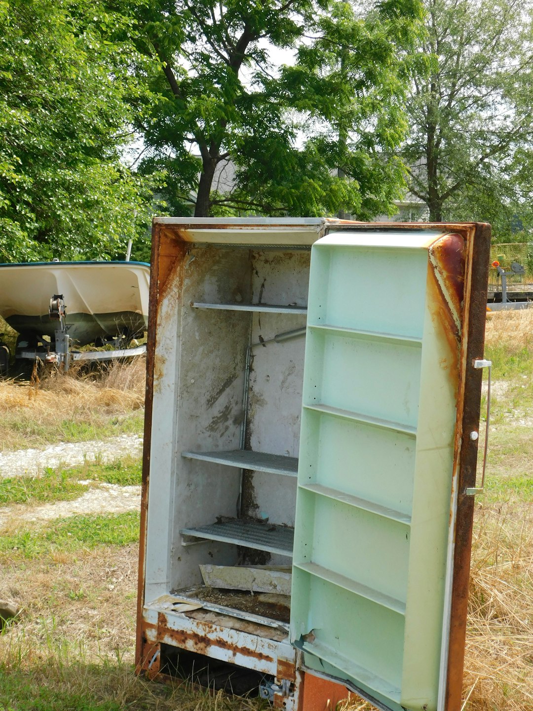 old-rusty-refrigerator-standing-outdoors-in-grass-kgdrpdutbw8